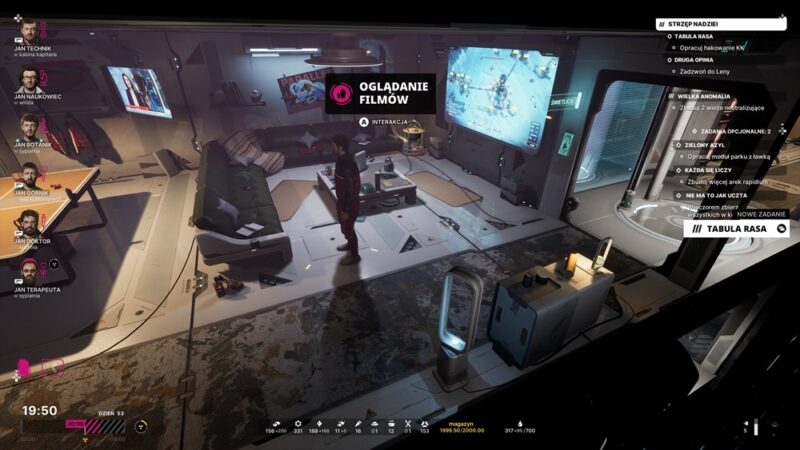 Świetlica z kanapami, stołem do ping ponga, windą i ekranem, na którym leci gameplay Frostpunka, po środku stoi Jan