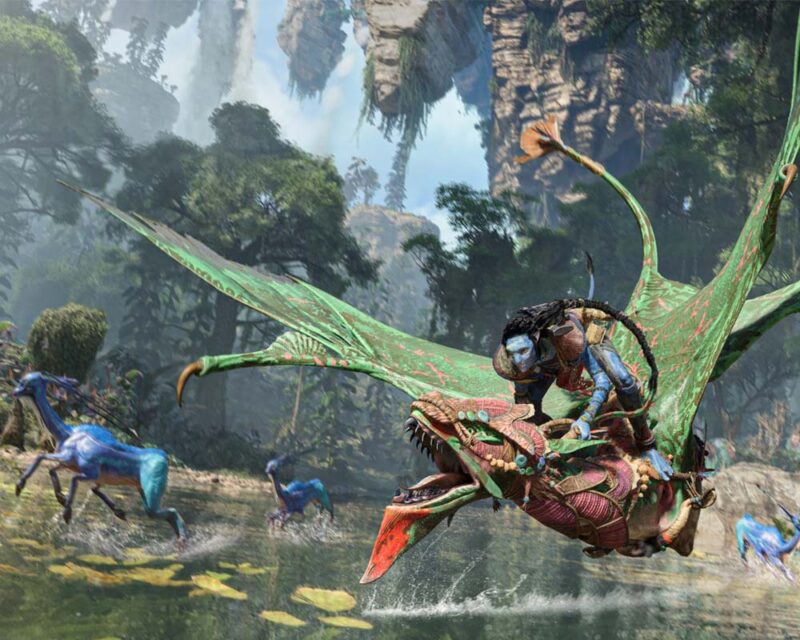 Na grafice widać postać Na'vi lecącą na ikranie nad taflą wody na tle lasu.