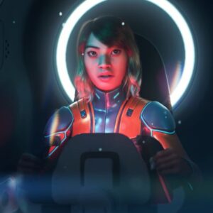 Na obrazku widzimy młodą kobietę w kombinezonie, siedzącą w kokpicie statku. Jej twarz jest oświetlona niebiesko-czerwonym światłem, a za jej głową świeci jasny, okrągły pierścień.