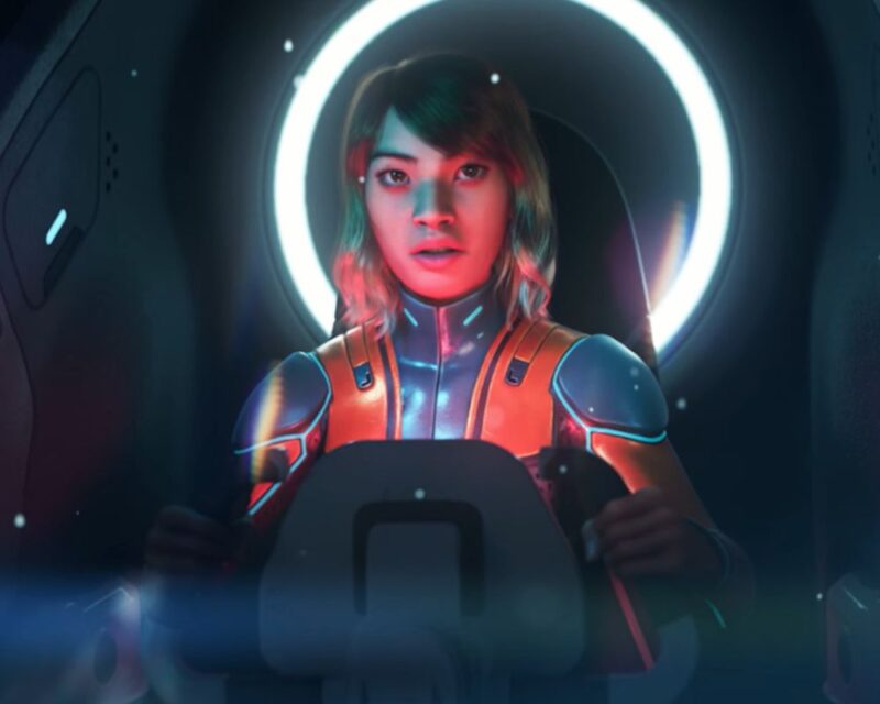Na obrazku widzimy młodą kobietę w kombinezonie, siedzącą w kokpicie statku. Jej twarz jest oświetlona niebiesko-czerwonym światłem, a za jej głową świeci jasny, okrągły pierścień.
