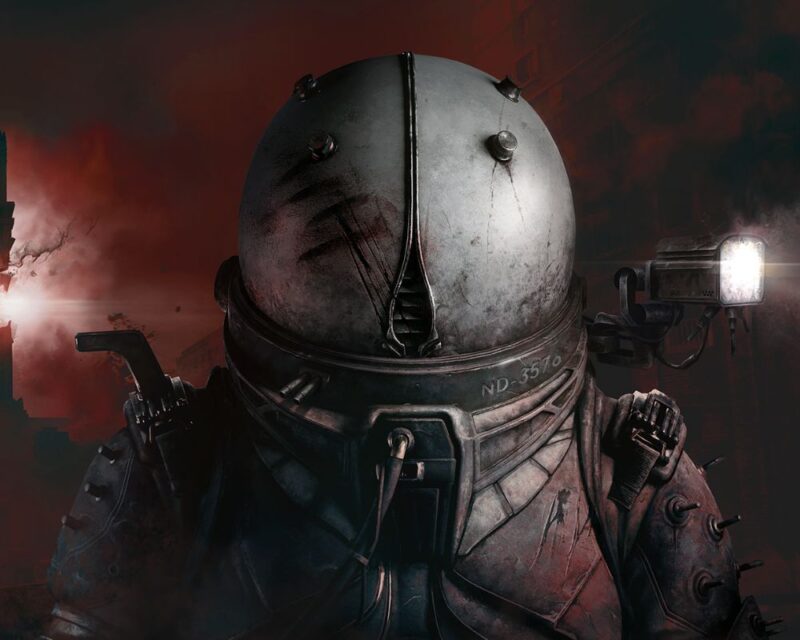 Na obrazku widać osobę w ciężkim, metalowym kombinezonie z hełmem na czerwonym tle. Z boku przymocowane jest światło, a na pancerzu widać ślady zużycia i numer ND-3576.