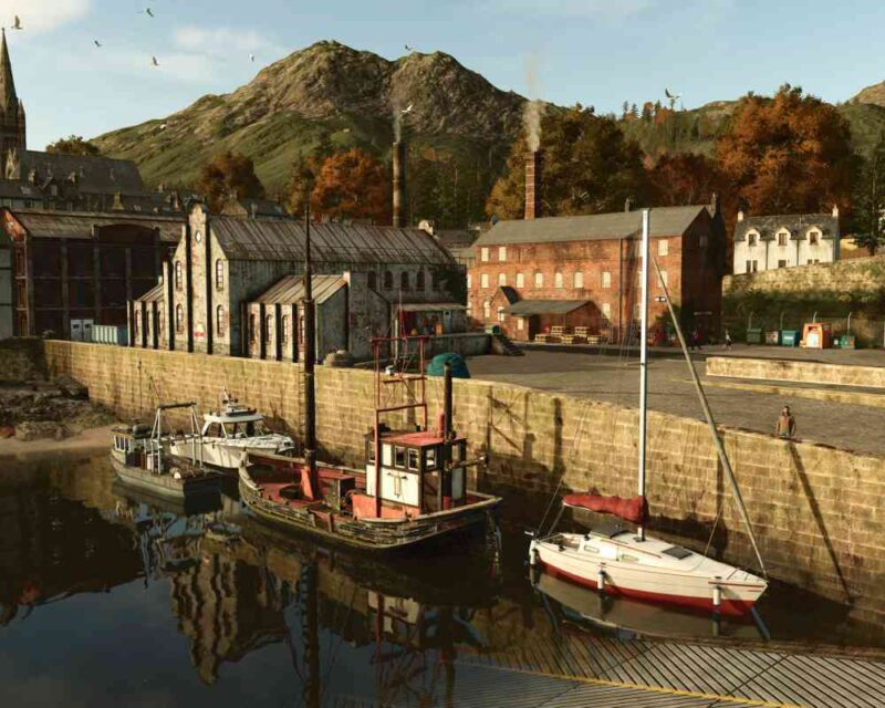 Zrzut ekranu z gry Farming Simulator 25 ukazujący szczegółowo odwzorowany port rybacki z otoczeniem przemysłowym, górami i jesiennym krajobrazem, będący częścią jednego z nowych dodatków do gry.