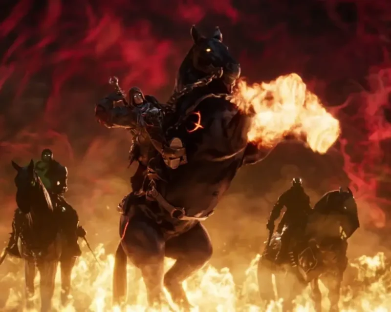 Kadr ze zwiastuna gry Darksiders 4, przedstawiający Czterech Jeźdźców Apokalipsy przemierzających płomienie piekła na demonicznych koniach, z centralnie ukazanym głównym jeźdźcem dosiadającym ognistego rumaka