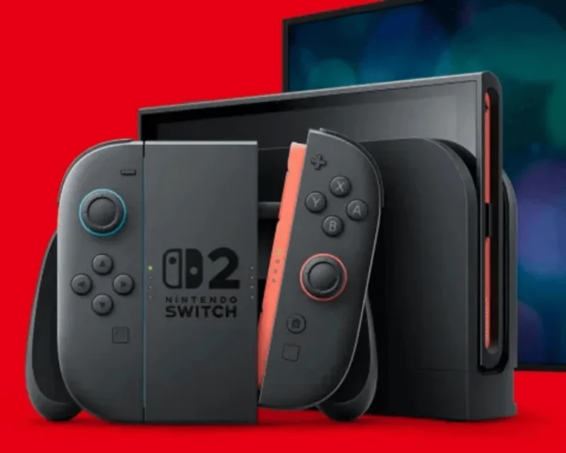 Konsola Nintendo Switch 2 w wersji z czarno-czerwonymi Joy-Conami, ustawiona na tle czerwonego ekranu.