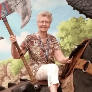 Shirley Curry, znana jako Skyrimowa Babcia, podczas wydarzenia gamingowego trzyma ogromny topór, symbolicznie nawiązując do świata Skyrim.