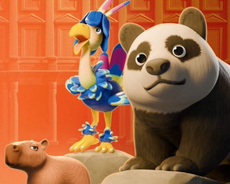 Obrazek przedstawia trzy animowane zwierzęta na tle, które wydaje się być pomarańczowo-czerwonym muzeum. Panda Wielka: Dominująca postać na pierwszym planie, po prawej stronie. Jest duża, ma typowe czarno-białe futro i spogląda bezpośrednio na widza z łagodnym, nieco zdziwionym wyrazem pyszczka. Opiera się na czymś, co wygląda jak skała. Ptak Egzotyczny: Znajduje się w centrum, za pandą. Jest to bardzo kolorowy ptak z niebiesko-żółto-fioletowym upierzeniem. Ma długie, strzeliste pióra na głowie i jest w pozycji jakby śpiewał lub krzyczał, z szeroko otwartym dziobem. Kapibara: Częściowo widoczna w lewym dolnym rogu. Ma spokojny, wręcz znudzony lub lekko sfochowany wyraz pyszczka i jest ujęta od boku. Cała scena ma jasne, nasycone kolory, a tło w odcieniach pomarańczu i czerwieni nadaje jej ciepły, a jednocześnie nieco formalny charakter.