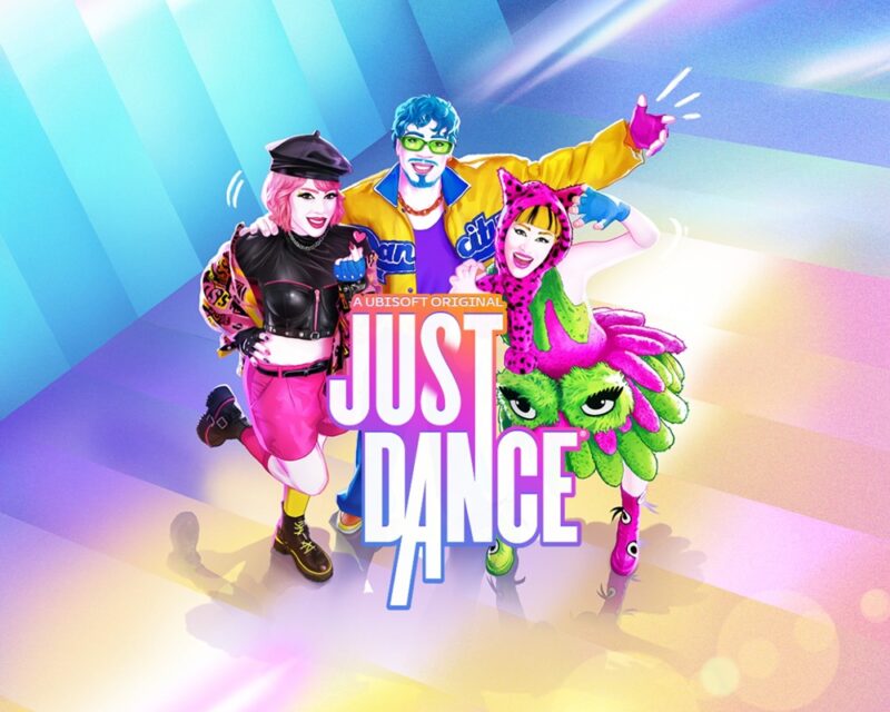 trzy osoby ubrane w kolorowe ubrania pozują wesoło do zdjęcia. Przed nimi logo "Just Dance", w tle niebieskożółte barw