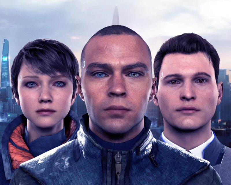 Grafika promocyjna przedstawiająca troje humanoidalnych androidów stojących obok siebie na tle futurystycznego miasta – centralna postać patrzy prosto w obiektyw, a dwie pozostałe znajdują się po bokach, podkreślając motyw sztucznej inteligencji i ludzkich emocji w futurystycznym świecie.