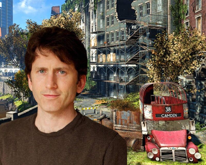 Na obrazku widać fotomontaż przedstawiający Todda Howarda, znanego producenta gier z Bethesda Game Studios, umieszczonego na tle scenerii z gry wideo, która prawdopodobnie nawiązuje do moda „Fallout: London”. Todd Howard znajduje się na pierwszym planie po lewej stronie, ubrany w prosty, brązowy t-shirt i patrzący bezpośrednio w stronę widza z lekkim uśmiechem. Tło ukazuje postapokaliptyczną wizję Londynu: po prawej stronie widać zniszczony, czerwony piętrowy autobus z napisem „38 Camden”, a za nim zrujnowane kamienice z powybijanymi oknami i widocznymi rusztowaniami. Całość otoczenia jest porośnięta dziką roślinnością i drzewami o jesiennych barwach, co nadaje kompozycji charakterystyczny klimat serii Fallout, łączący miejską ruinę z odradzającą się naturą.
