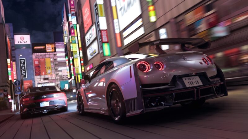 Co wiemy o Forza Horizon 6. Kadr przedstawia dwa silnie ztuningowane samochody widziane z tyłu, ścigające się ulicą japońskiego miasta nocą przy świetle neonów.