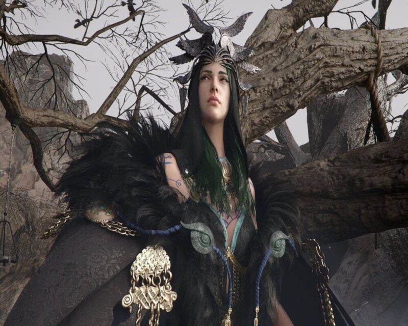 Zrzut ekranu prezentujący imponujący poziom detali w Crimson Desert. Postać nosi skomplikowany strój łączący czarne materiały z elementami zbroi i biżuterii. Na jej skórze można dostrzec niebieskie, plemienne tatuaże. Surowe, pozbawione liści drzewa w tle i szare niebo nadają scenie chłodny, nordycki klimat.