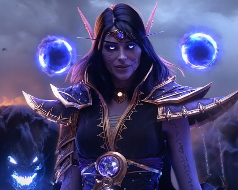 Fantastyczna ilustracja przedstawiająca elficką czarodziejkę o fioletowej skórze i długich, ciemnych włosach, w bogato zdobionej zbroi i z klejnotem na czole, stojącą w mrocznej scenerii z dwoma świecącymi, niebieskimi kulami energii unoszącymi się za jej głową oraz cienistym, demonicznym wilkiem u boku.