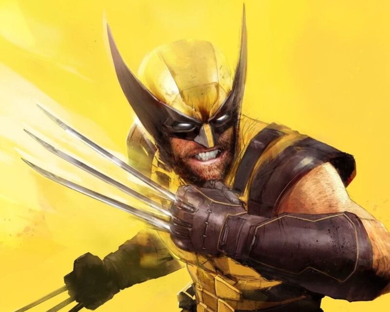 Na zdjęciu widać głównego bohatera gry Marvel's Wolverine - Wolverinea. To mężczyzna w żółto-czarnej masce zasłaniającej włosy i oczy, z brodą i zaciśniętą szczęką, ma na sobie żółto-czarny strój odsłaniający ramiona, przedramiona ma zakryte czarnymi rękawicami, ręce zaciśnięte w pięści, z kłykci wychodzą długie ostrza. Przybrał postawę bojową, tło jest żółte