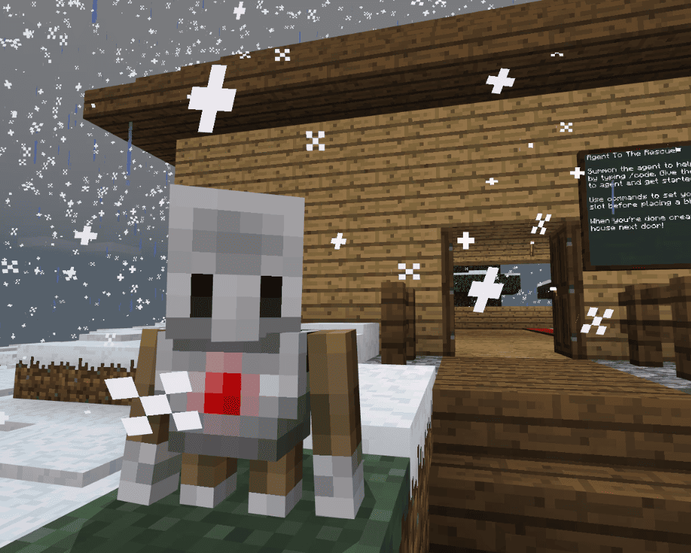 Robot Agent z Minecraft Education Edition stoi na śniegu przed drewnianym domem podczas opadów śniegu. W tle widoczna jest tablica z instrukcją „Agent To The Rescue”, tłumaczącą podstawy programowania i wydawania komend w grze.