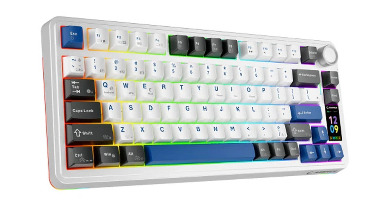 Zdjęcie prezentuje bezprzewodową klawiaturę mechaniczną o kompaktowym układzie 75%, która wyróżnia się wielokolorową, kontrastową estetyką oraz wbudowanymi elementami multimedialnymi. Urządzenie posiada białą obudowę i mieszany zestaw nakładek na klawisze: dominująca biel sekcji alfanumerycznej sąsiaduje z czarnymi klawiszami funkcyjnymi oraz niebieskimi akcentami na przyciskach Enter, Spacja, Escape i strzałkach. W prawym górnym rogu znajduje się duża, srebrna rolka do regulacji głośności, a poniżej niej umieszczono pionowy, kolorowy wyświetlacz LCD pokazujący aktualną godzinę oraz status urządzenia. Całość uzupełnia dynamiczne podświetlenie RGB, które tworzy tęczową łunę pod klawiszami oraz wzdłuż bocznej krawędzi obudowy, nadając klawiaturze nowoczesny i zaawansowany technologicznie wygląd.