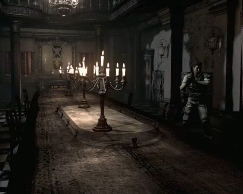 Zrzut ekranu z gry Resident Evil. Prezentuje jednego z bohaterów gry (z bronią w ręku) w ciemnym pomieszczeniu z długim stołem i krzesłami przy nim. Na blacie stoją wieloramienne kandelabry. Na ścianach zaś wiszą latarnie, obrazy oraz ozdoba w postaci skrzyżowanych na tarczy mieczy. Pomieszczenie utrzymane jest w stylu neogotyku z naleciałościami stylu wiktoriańskiego.