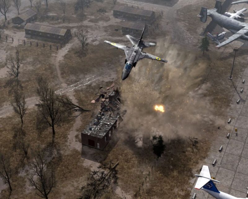 Screen z Ukrainian Warfare: Gostomel Heroes, prezentujący ukraiński samolot szturmowy Su-24 bombardujący obiekt przy lotnisku. Na obrazku widać eksplozję, wylatujące w powietrze fragmentu budynku, a także zaparkowane na miejscach postojowych samoloty transportowe.
