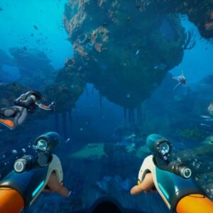 Zrzut ekranu z gry Subnautica 2 przedstawiający podwodną scenę widzianą z perspektywy pierwszej osoby. Na pierwszym planie widoczne są ręce postaci w pomarańczowym skafandrze nurkowym, na których zamontowane są futurystyczne urządzenia przypominające rękawice lub narzędzia z wbudowanymi lampami. Wokół unoszą się pęcherzyki powietrza. Po lewej stronie płynie inny nurek w jasnym skafandrze z plecakiem tlenowym, wyciągający rękę przed siebie. W centrum kadru znajduje się ogromna formacja skalna porośnięta koralowcami i roślinnością, unosząca się nad dnem oceanu, z której zwisają długie, przypominające korzenie struktury. W wodzie pływają liczne ryby i morskie stworzenia, a w tle widać dalsze fragmenty podwodnego krajobrazu z rafami i skałami skąpanymi w jasnoniebieskim świetle oceanu.