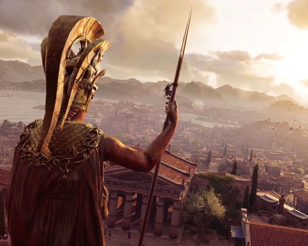 Zrzut ekranu prezentujący widok z gry Assassin's Creed: Odyssey z perspektywy zza posągu Ateny z widokiem na starożytne, greckie polis