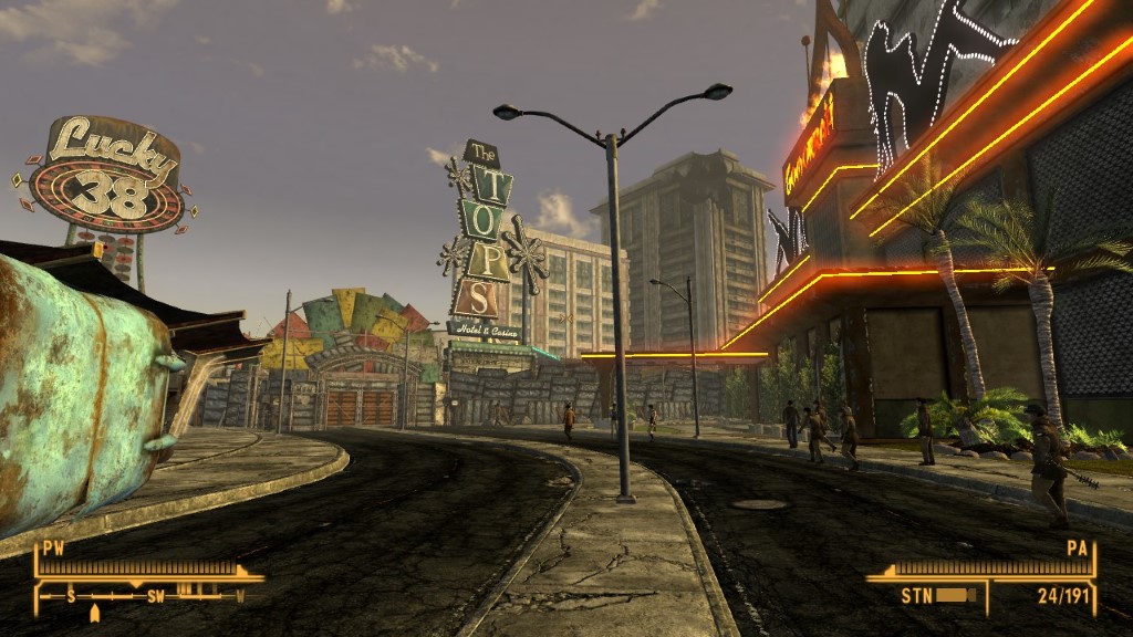 Ciemna dwupasmowa ulica, na środku której stoi szara latarnia. Wokół świecą się liczne różnokolorowe neony.