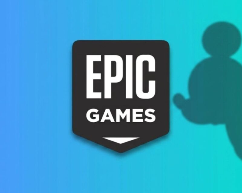 Zrzut przedstawia logo Epic Games na tle gradientu w odcieniach niebieskiego i turkusu; po prawej stronie widoczny jest cień sylwetki Myszki Miki, nawiązujący do współpracy z Disneyem.
