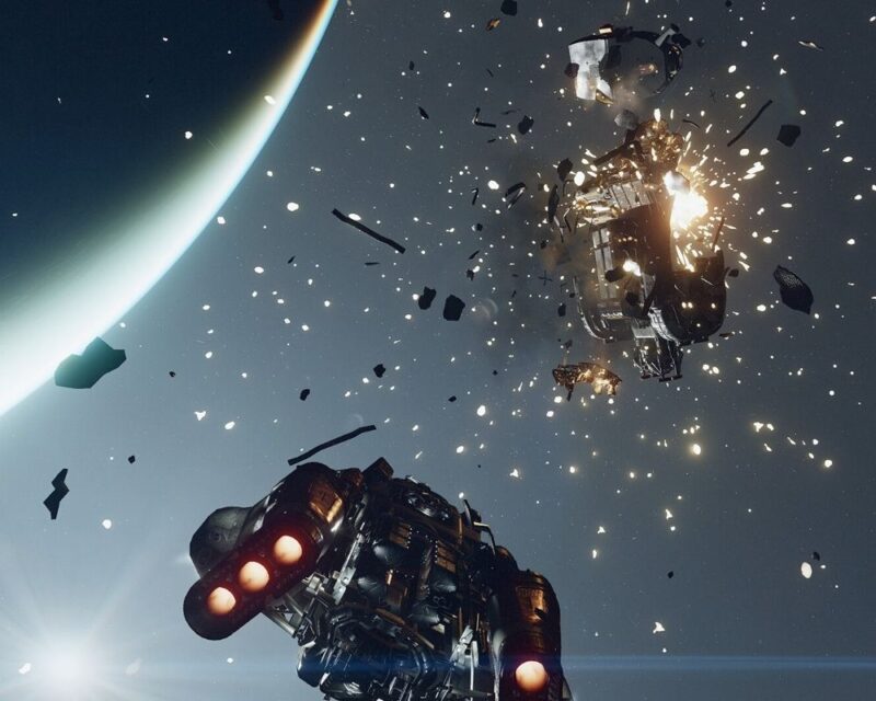 Eksplodujący statek kosmiczny na orbicie planety, z licznymi odłamkami unoszącymi się w przestrzeni oraz drugim statkiem przelatującym w pobliżu - grafika z gry Starfield.