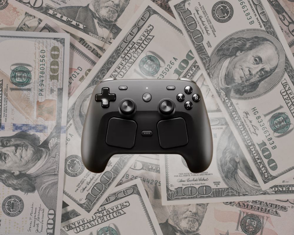 Czarny kontroler Valve Steam Controller na tle rozrzuconych banknotów 100 dolarów amerykańskich. Grafika sugeruje wysoką cenę Steam Controller