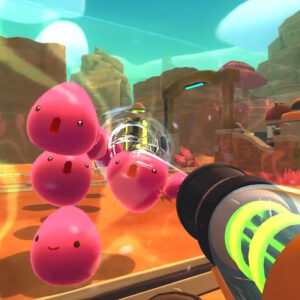 Na obrazku widać screen z gry Slime Rancher. Przedstawia kolorową, bajkową scenę z pustynnym krajobrazem. W tle znajdują się skały i futurystyczne konstrukcje. Na pierwszym planie widzimy kilka różowych slime'ów, które podskakują. Z prawej strony obrazka widać vackpack, czyli urządzenie odpowiedzialne za zbieranie rzeczy w grze.