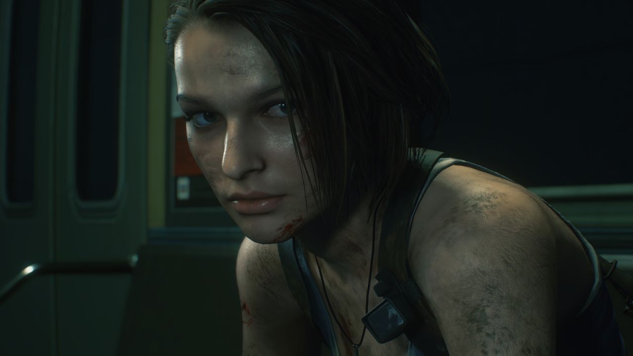 Na obrazku widać Jill Valentine z gry Resident Evil 3, siedzącą w wagonie metra. Ma krótkie, ciemne włosy, zabrudzoną skórę oraz drobne zadrapania na twarzy i ramionach. Ubrana jest w ciemny top na ramiączkach i nosi naszyjnik. Wnętrze wagonu jest słabo oświetlone i utrzymane w ciemnej, zielonkawo-niebieskiej kolorystyce.