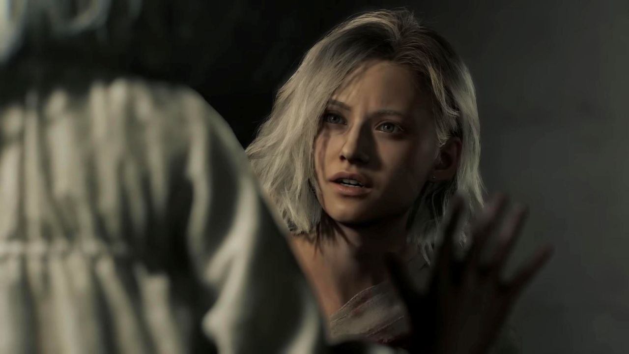 Na obrazku widać Grace Ashcroft z Resident Evil Requiem. Ma krótkie, jasne blond włosy i spogląda przed siebie z zaniepokojonym wyrazem twarzy. Na pierwszym planie widoczna jest rozmyta postać oraz uniesiona dłoń, a cała scena utrzymana jest w ciemnej kolorystyce.