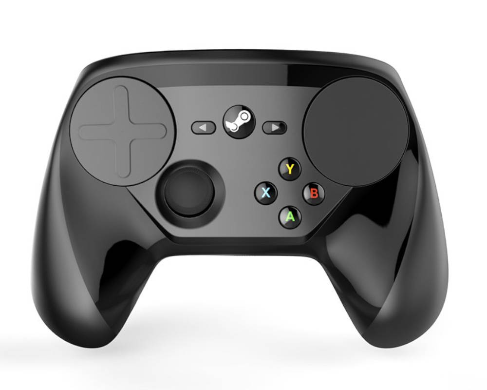 Zdjęcie przedstawia czarny, błyszczący kontroler do gier Steam Controller, umieszczony na jednolitym białym tle. Urządzenie charakteryzuje się unikalnym układem elementów sterujących, w którym dominują dwa duże, okrągłe panele dotykowe (trackpady) umieszczone po bokach górnej części obudowy, z których lewy posiada wytłoczony kształt krzyżaka (D-pad). Pomiędzy panelami, w centralnym punkcie, znajduje się okrągły przycisk z logo Steam, a po jego bokach dwa mniejsze przyciski funkcyjne ze strzałkami. Poniżej lewego panelu dotykowego umieszczono pojedynczą gałkę analogową, natomiast po prawej stronie znajduje się zestaw czterech kolorowych przycisków akcji oznaczonych literami A (zielony), B (czerwony), X (niebieski) i Y (żółty).