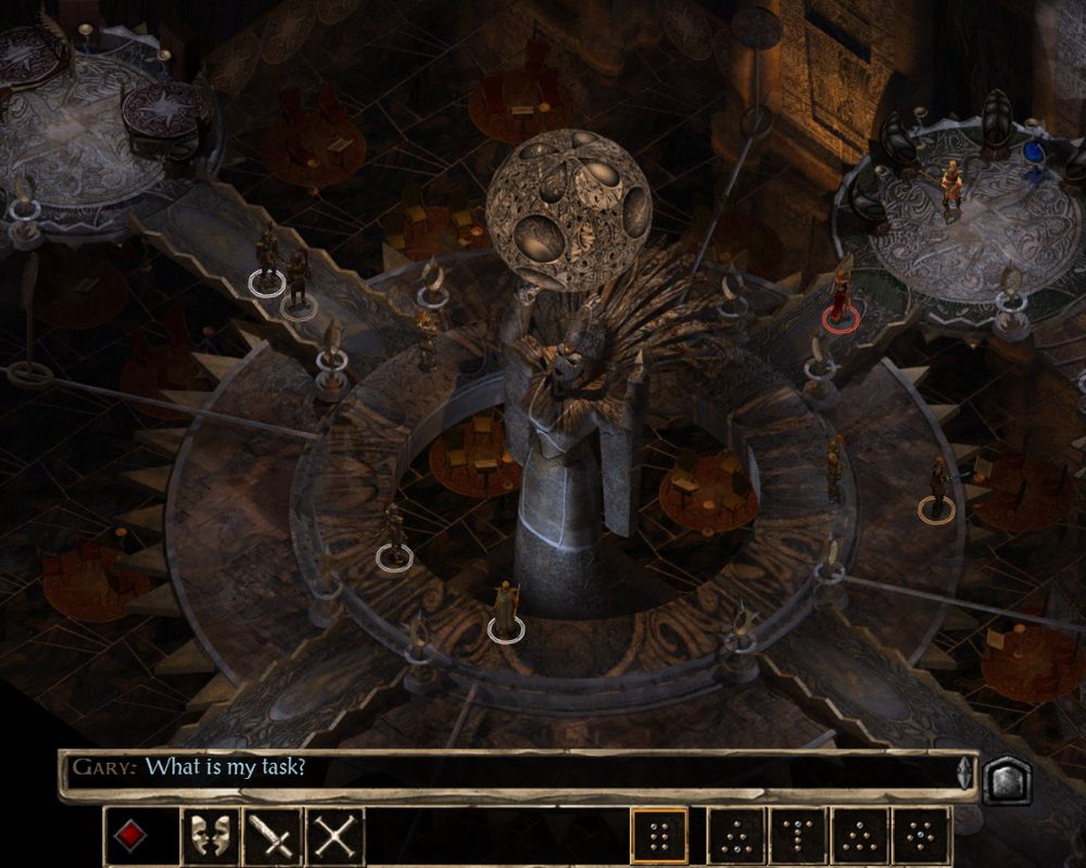 Kadr z klasycznej gry komputerowej Baldur's Gate II. Widok izometryczny na monumentalną, mroczną salę z kamienną architekturą w kształcie okręgów i pomostów. W samym środku wznosi się potężny posąg postaci unoszącej nad głową wielką, dziurkowaną sferę przypominającą księżyc. Wokół pomnika rozstawione są małe postacie bohaterów z zaznaczonymi okręgami u stóp (w tym jeden czerwony, oznaczający wroga lub postać neutralną). Na dole ekranu znajduje się czarny pasek interfejsu z ikonami akcji oraz oknem dialogowym, w którym wyświetla się kwestia: „Gary: What is my task?”.