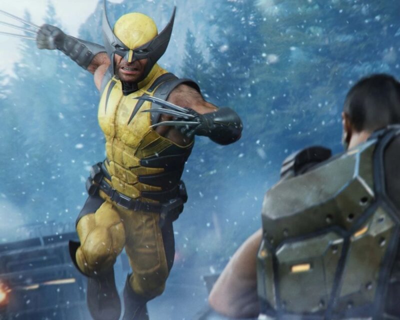 Grafika przedstawia Wolverine’a z gry Marvel's Wolverine w żółto-czarnym kostiumie, który z wysuniętymi szponami rzuca się do ataku na przeciwnika stojącego na pierwszym planie. Akcja rozgrywa się w ośnieżonym lesie, a w powietrzu unoszą się płatki śniegu. Wolverine znajduje się w centrum kadru i wygląda, jakby był w trakcie skoku lub szarży. Po prawej stronie widoczna jest postać odwrócona plecami do obserwatora, ubrana w masywną zieloną zbroję. W tle można dostrzec drzewa oraz fragment pojazdu. Dominują odcienie błękitu, szarości i żółci.